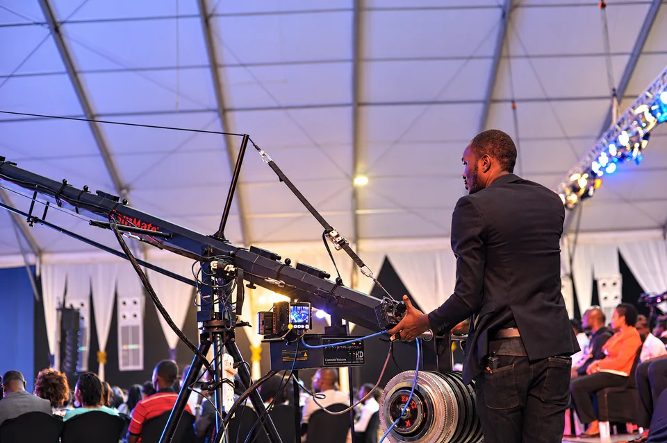 Cosmic production operator controlling a camera crane at a live event